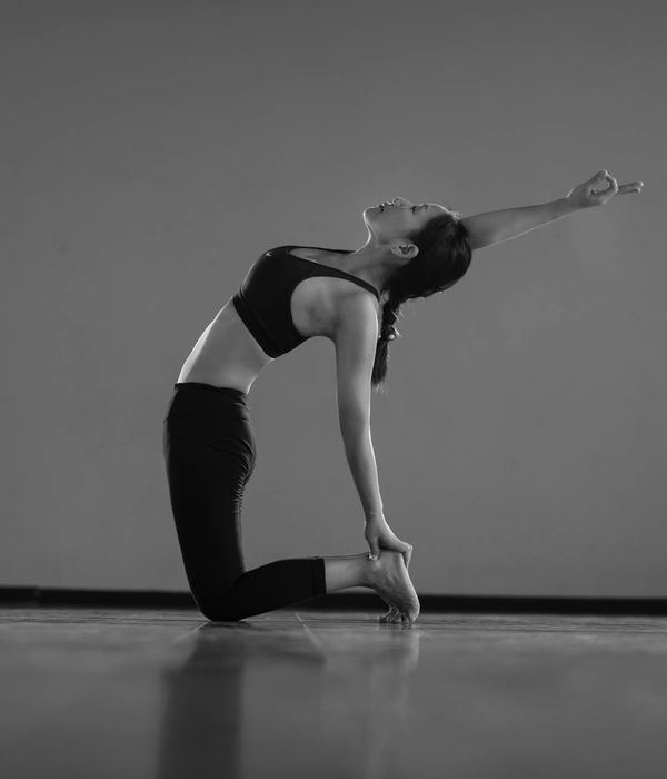 Woman performing a fluid yoga flow pose in a calm setting.